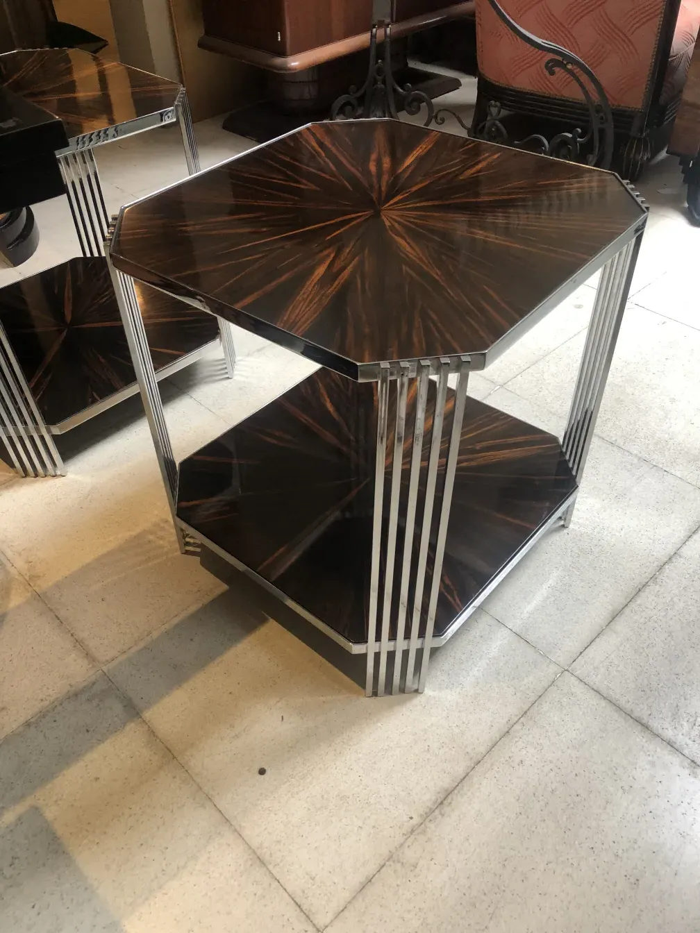 Duas mesinhas antigas com formas geométricas e design elegante, embelezando um ambiente clássico.