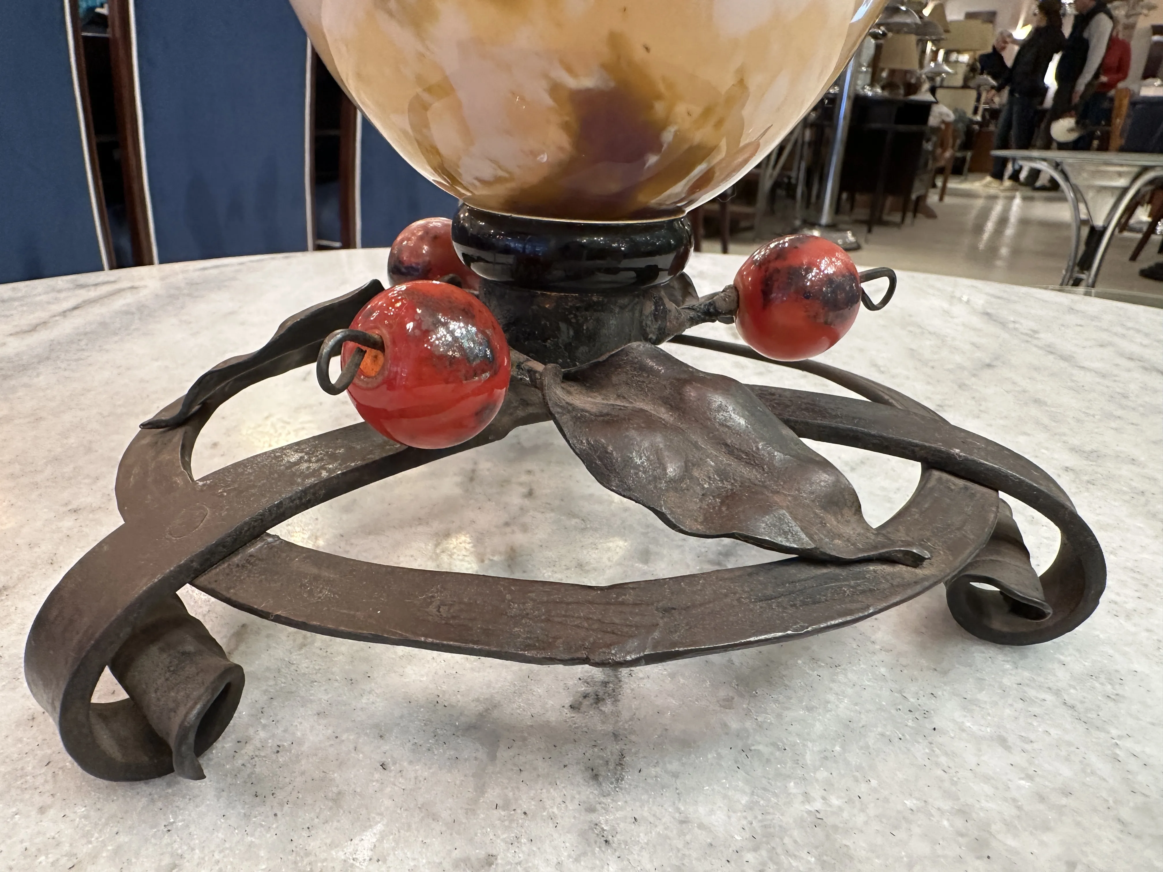 Base decorativa de metal con detalles en rojo y hojas, antiguo