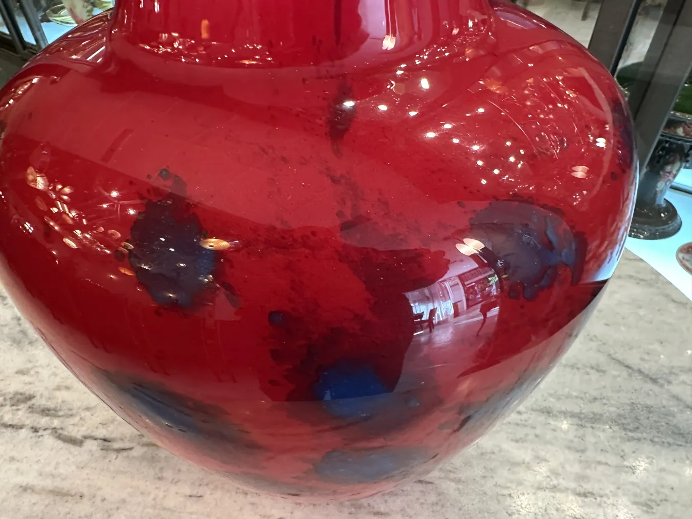 Red glass vase featuring Schneider's signature decoration