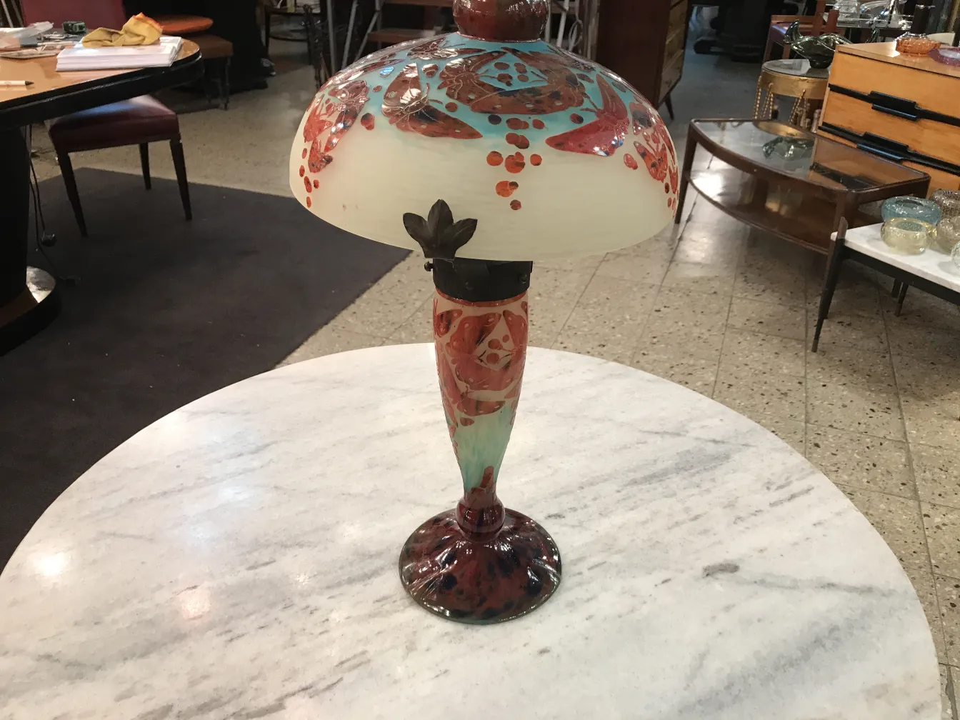 古董灯具，带有色彩丰富的设计和签名玻璃Le Verre，放在桌子上