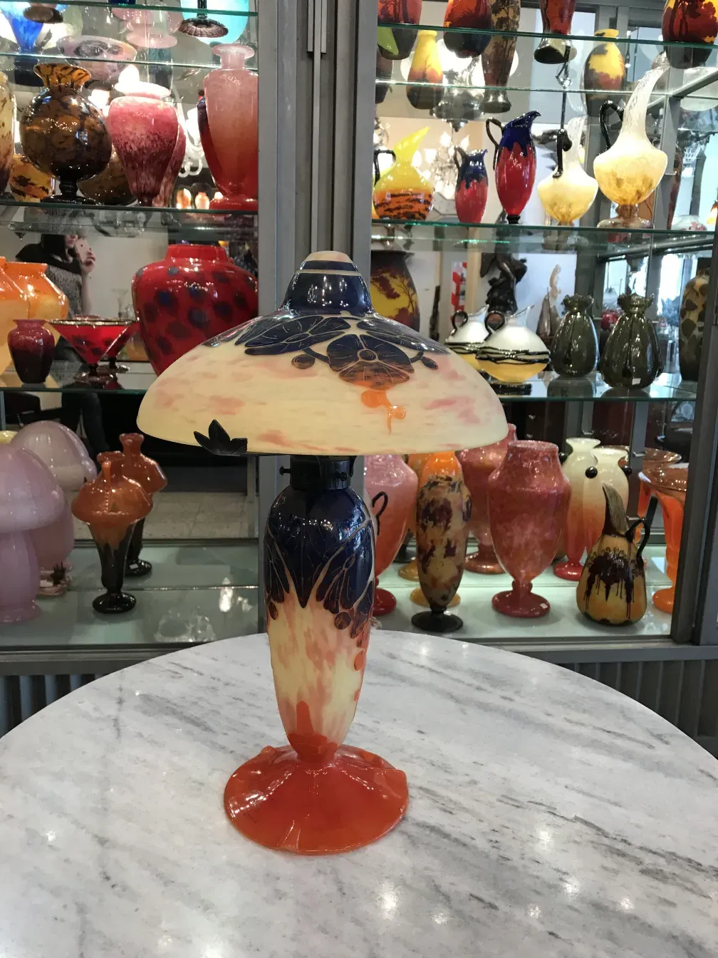 Лампа из стекла с подписью Le Verre с яркими цветами, окруженная антиквариатом