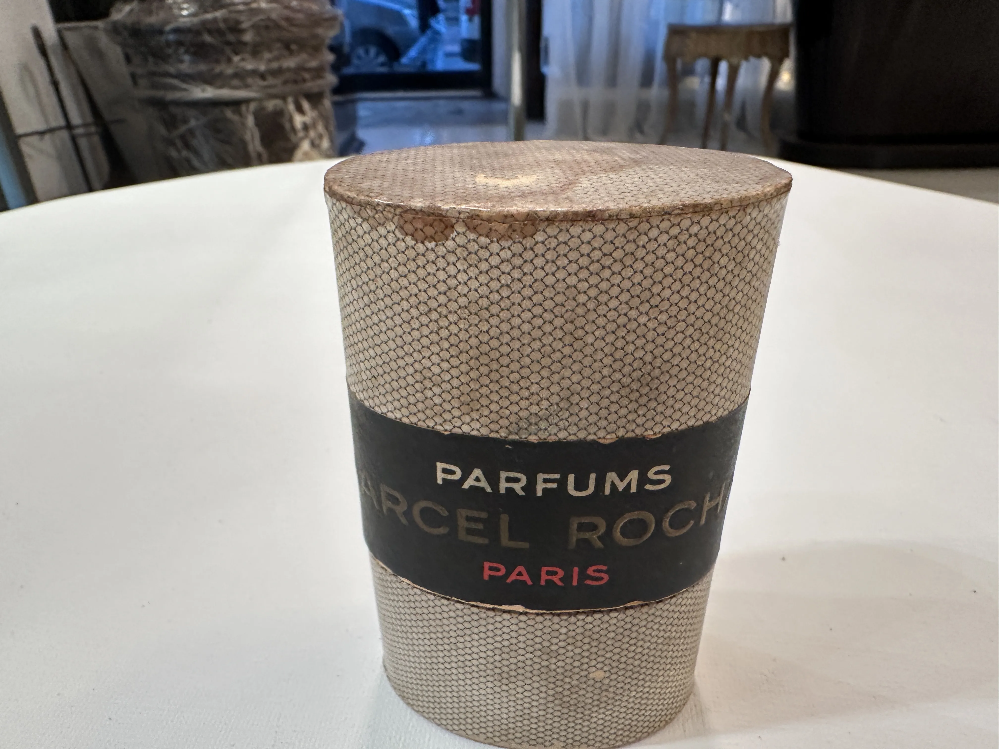 Flacon de parfum ancien avec des détails noir et doré.