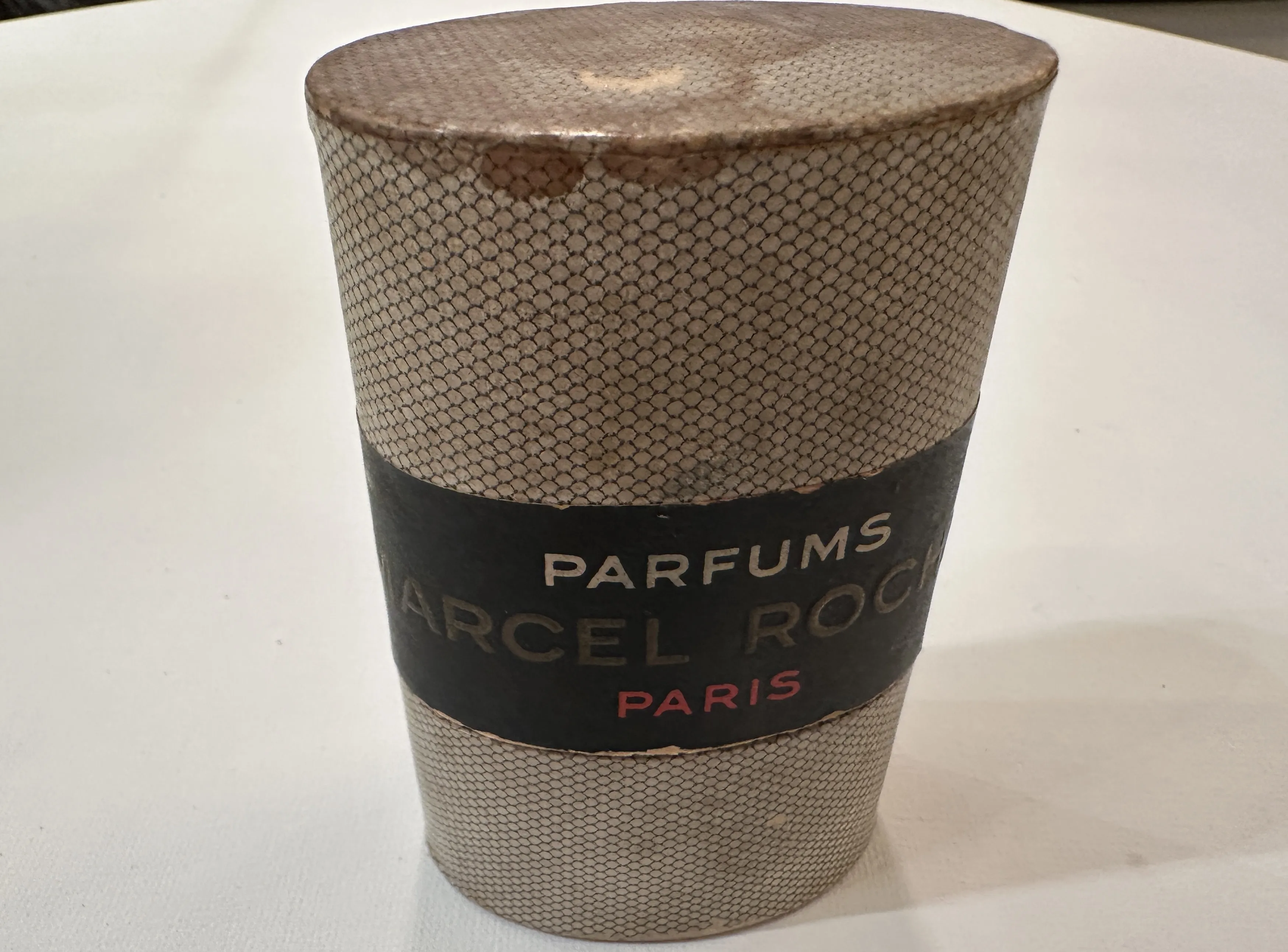 Antike Parfümflasche mit detailliertem Deckel und Etikett.