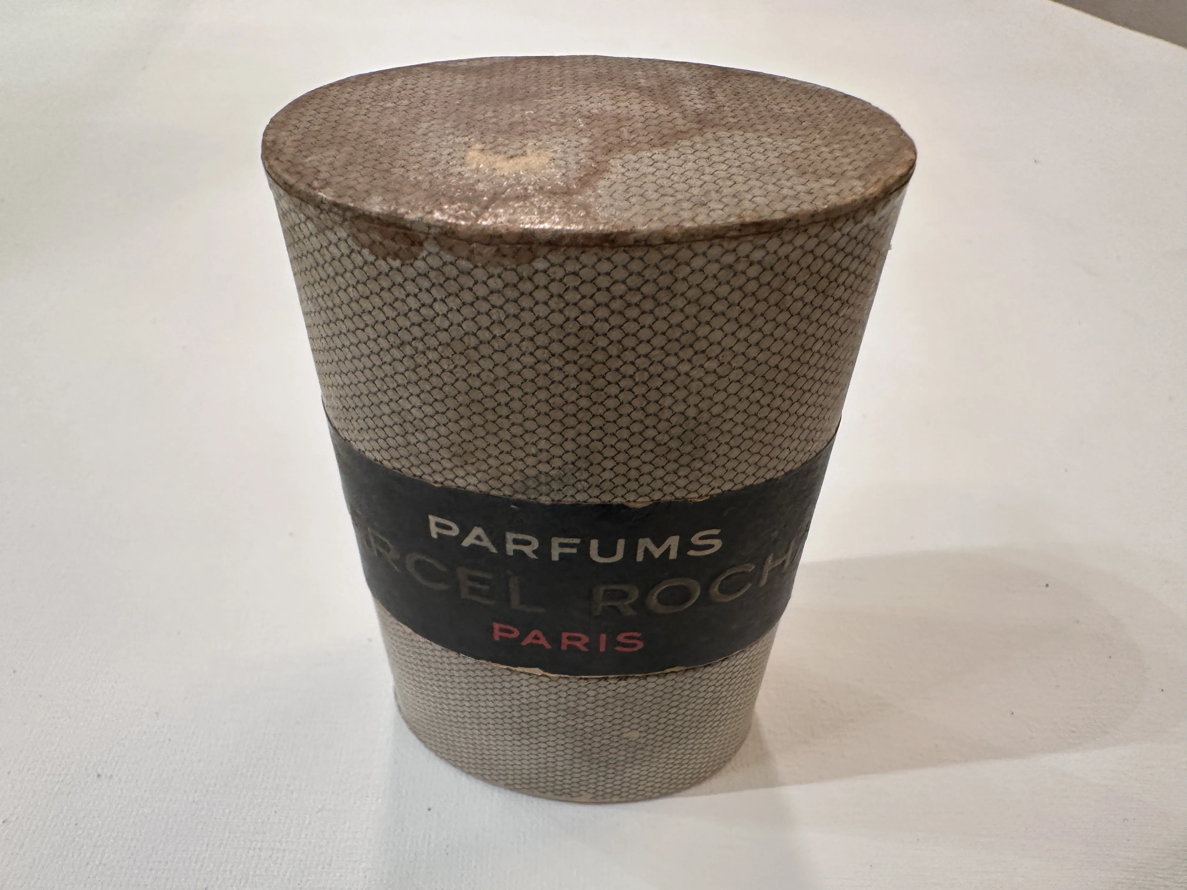 Frasco de perfume antiguo con diseño clásico de París, detalles visibles en la etiqueta.