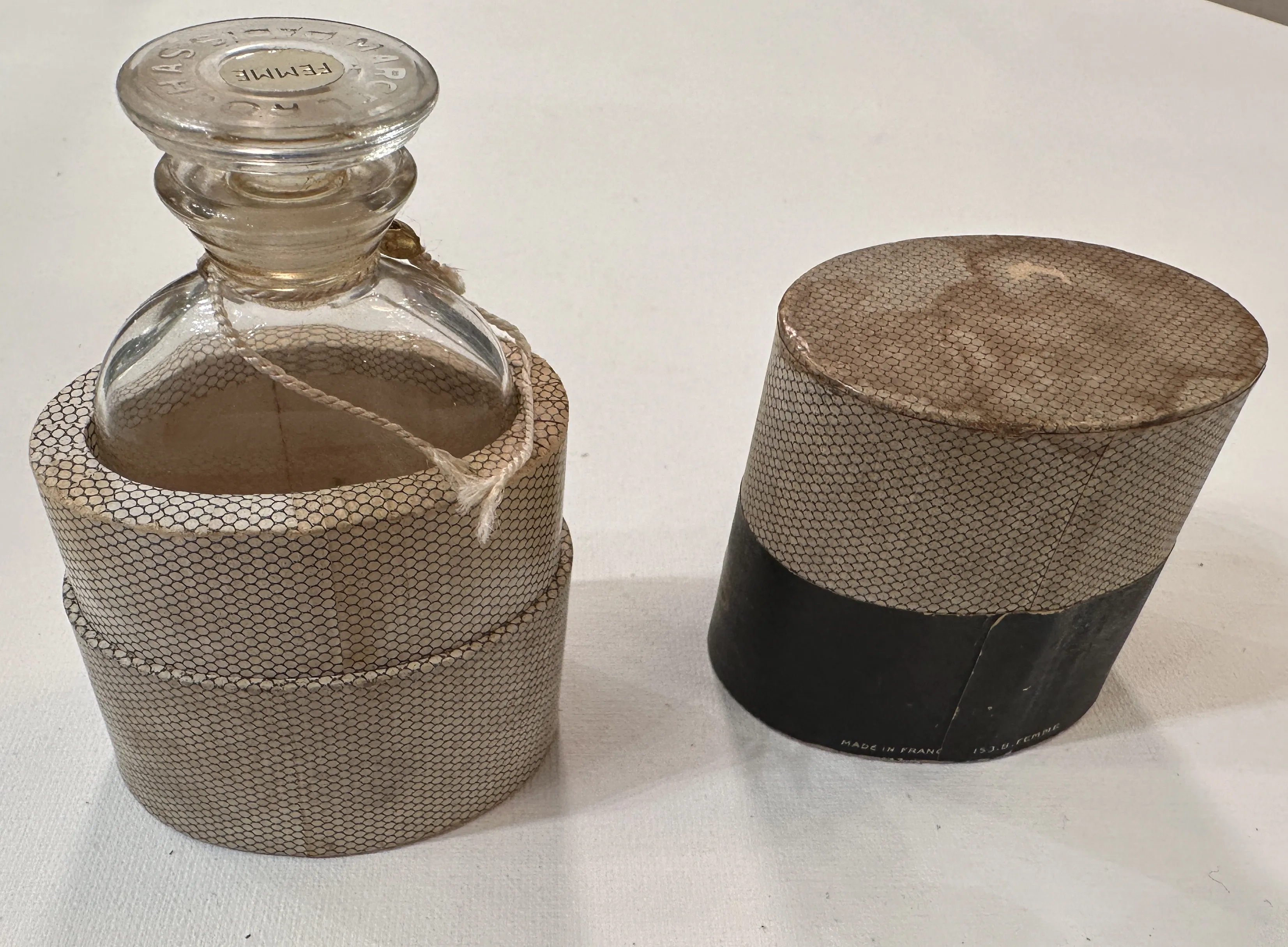 Antike Parfümflasche mit dekorativem Deckel in neutralem Hintergrund