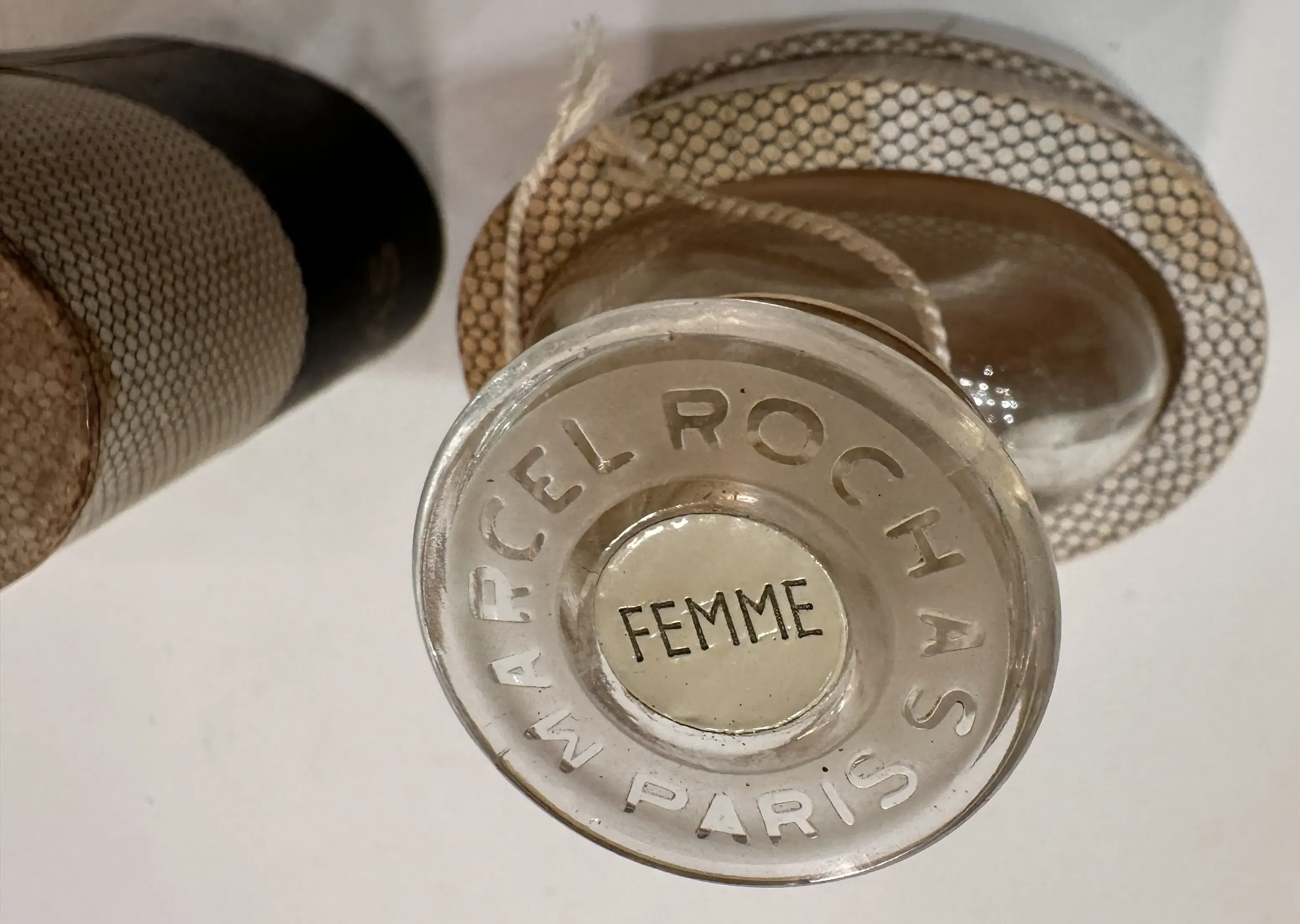 Un frasco de perfume antiguo con un diseño elegante, acompañado de un estuche decorativo