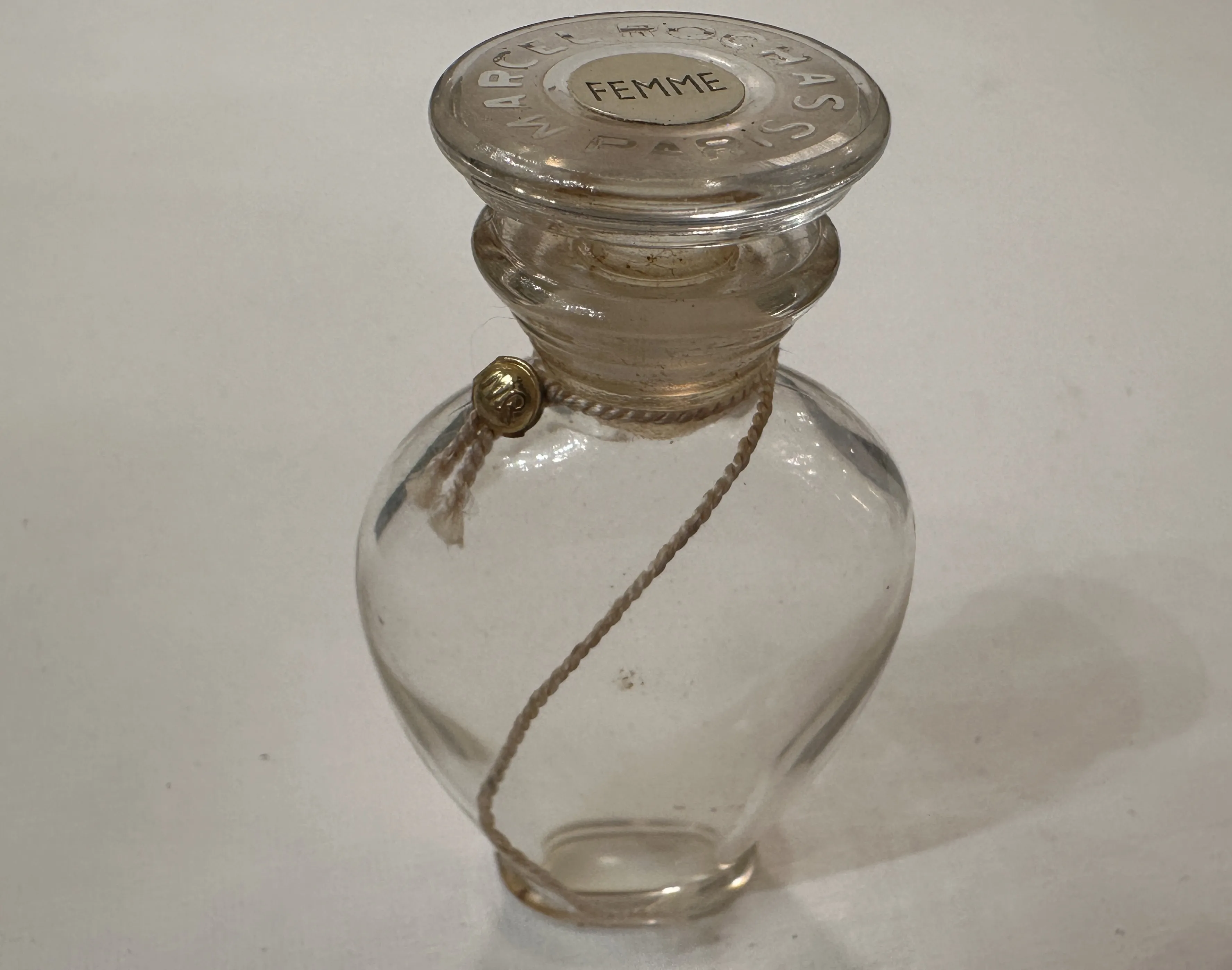 frasco de perfume antiguo con tapa de vidrio y cuerda decorativa