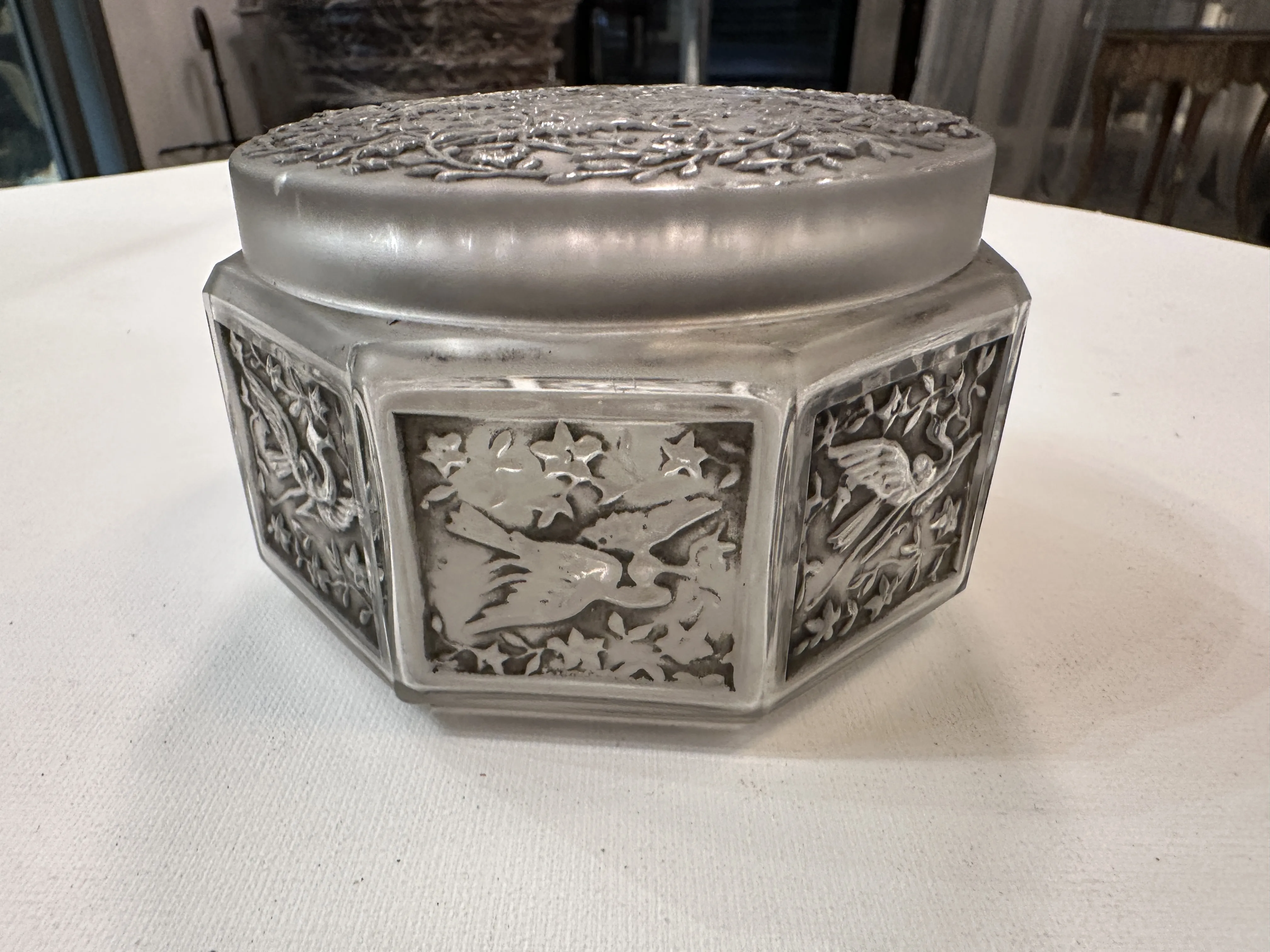 Caja antigua con detalles decorativos en relieve, con motivos florales y animales.