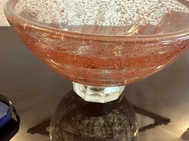 Antique signed Marinot glass with bright red hue on clear base, showing visible details.
