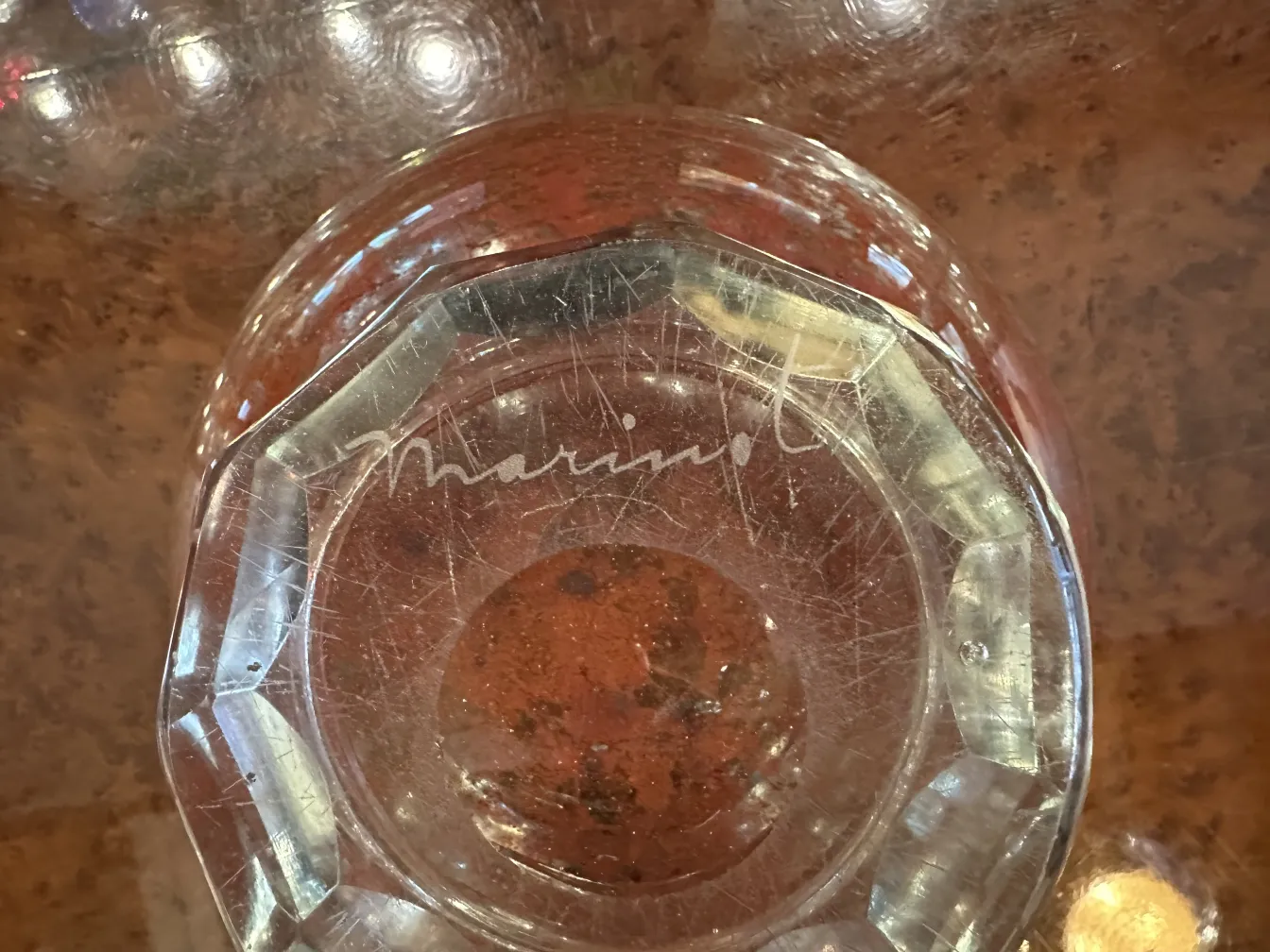 Antique signed Marinot glass with bright red hue on clear base, showing visible details.