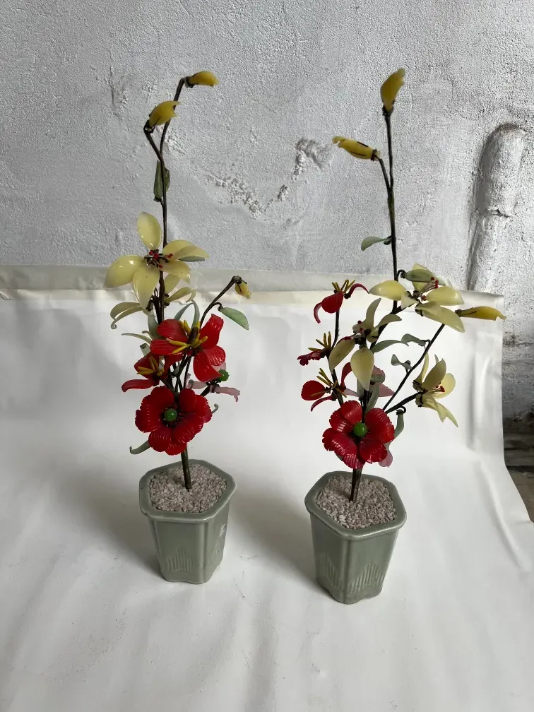 Antiker Bonsai mit roten und gelben Blumen in Töpfen.