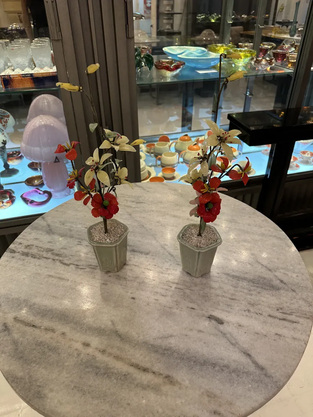 Bonsai antique sur une table en marbre avec des fleurs rouges et blanches