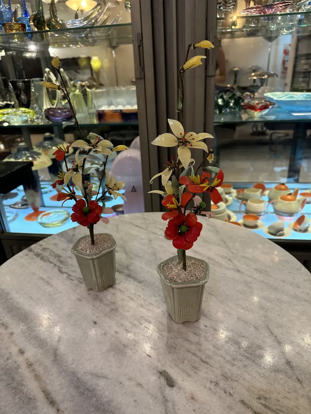 Alter dekorativer künstlicher Bonsai mit bunten Blumen.