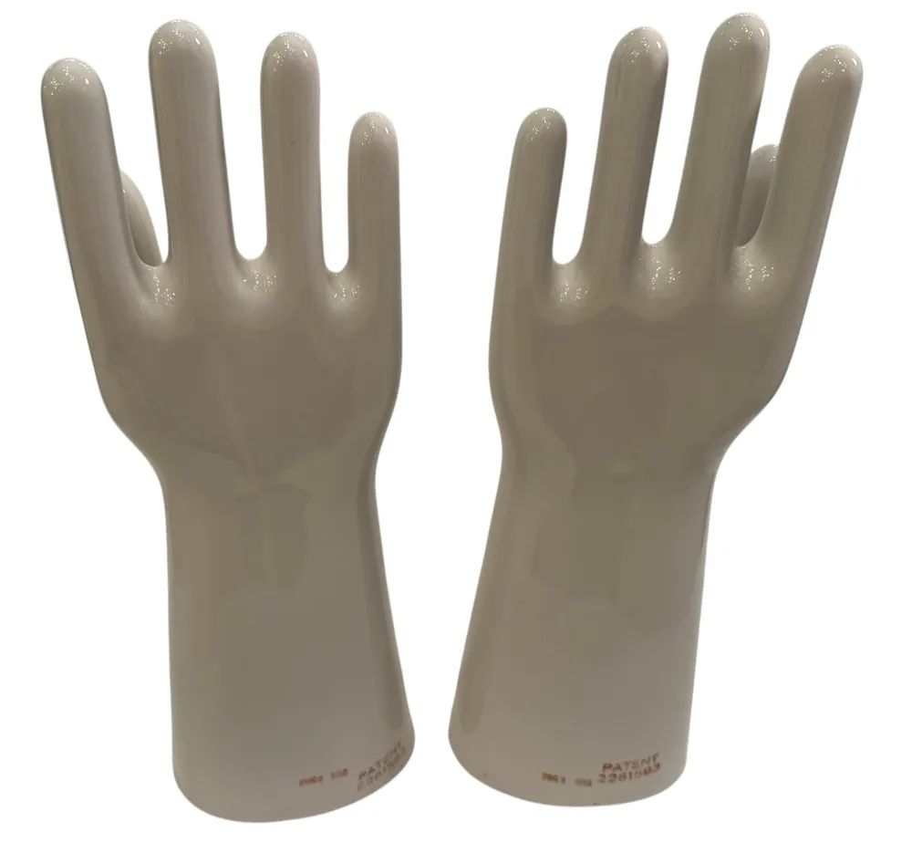 Paire de mains en céramique, anciennes et brillantes, présentant des détails de la forme dans un cadre neutre.
