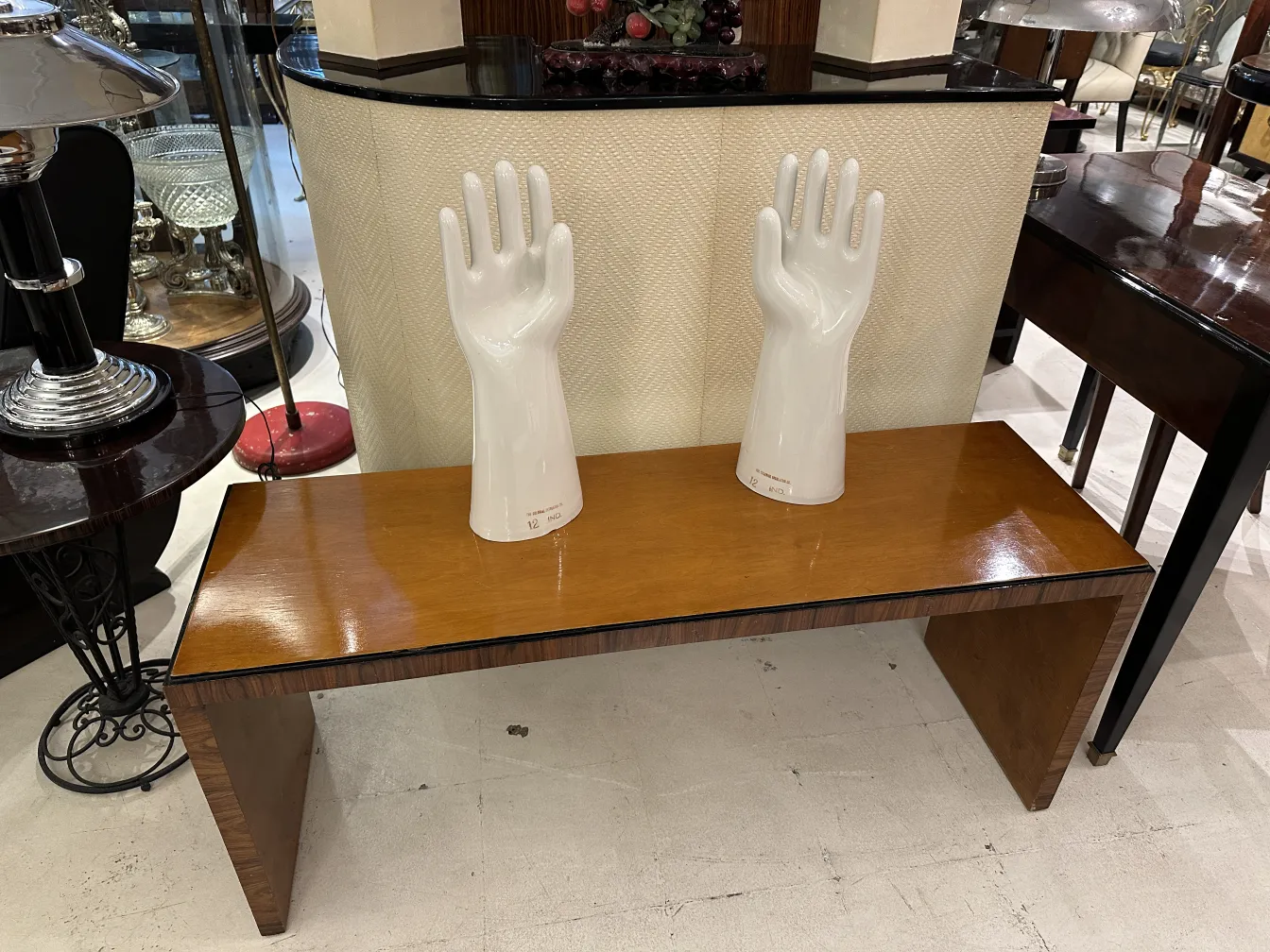Par de mãos de cerâmica, antigas e brilhantes, mostrando detalhes da forma em um ambiente neutro.