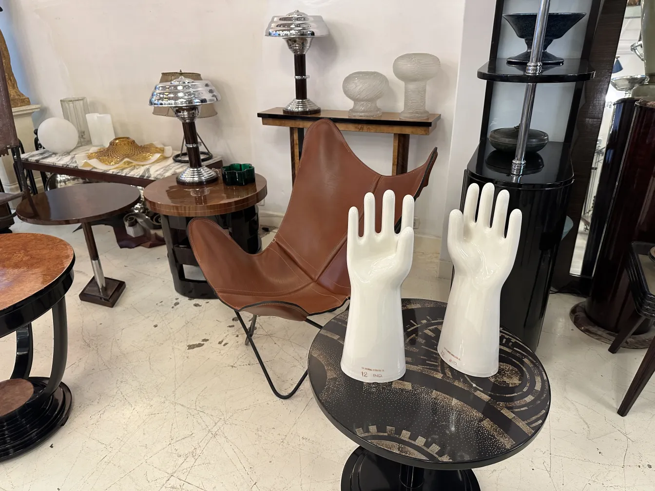 Coppia di mani in ceramica, antiche e lucide, con dettagli nella forma in uno sfondo neutro.