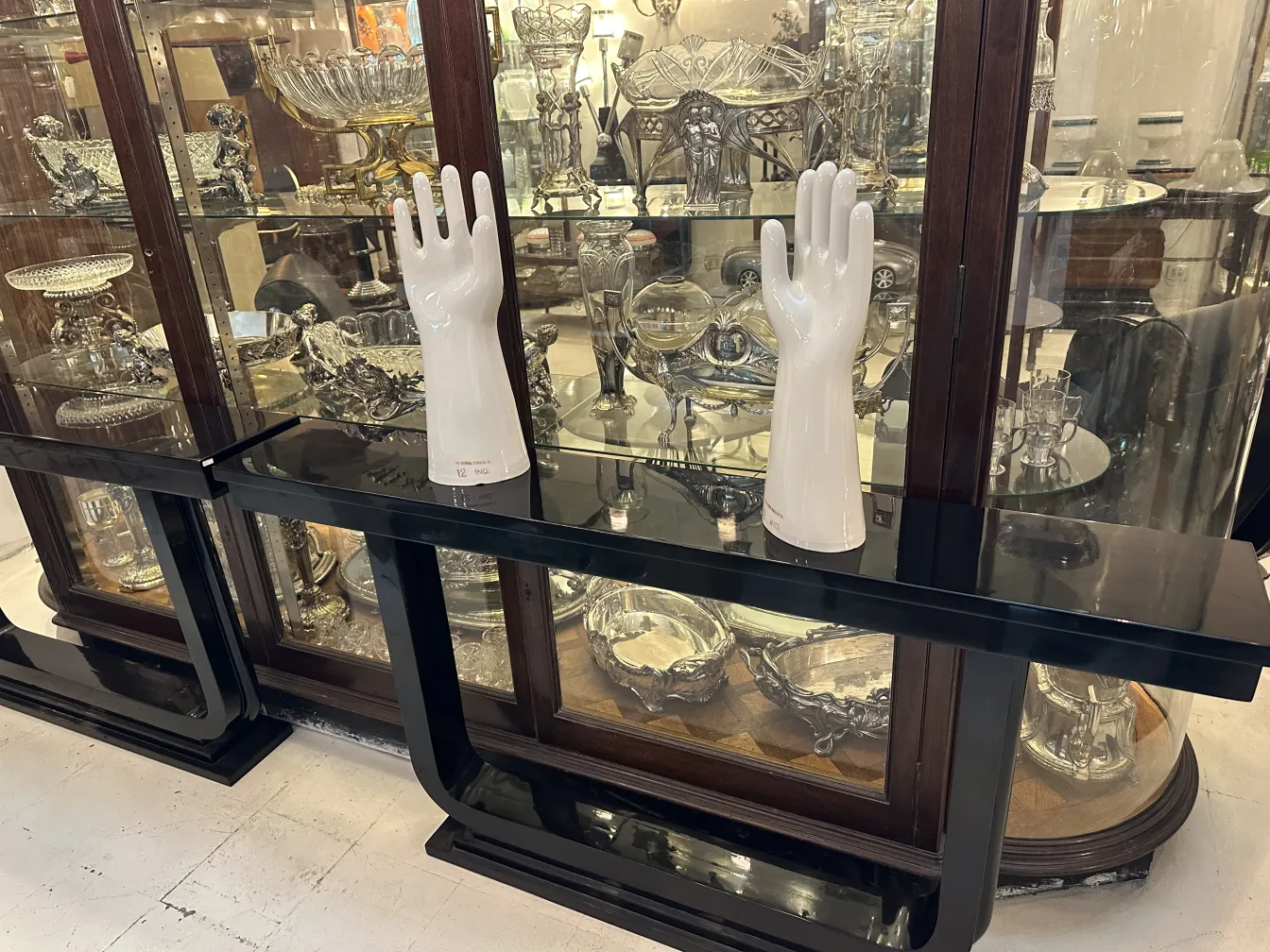 Paire de mains en céramique, anciennes et brillantes, présentant des détails de la forme dans un cadre neutre.