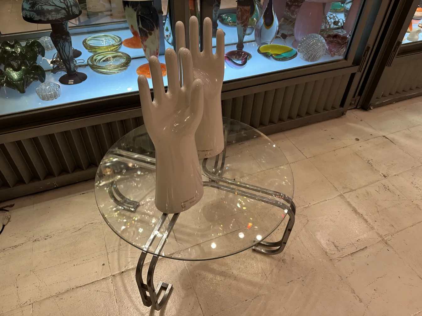 Par de mãos de cerâmica, antigas e brilhantes, mostrando detalhes da forma em um ambiente neutro.