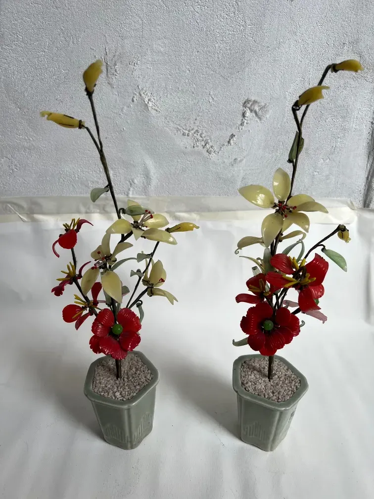 Bonsái antiguo en un florero de cerámica, decorado con flores rojas y amarillas.
