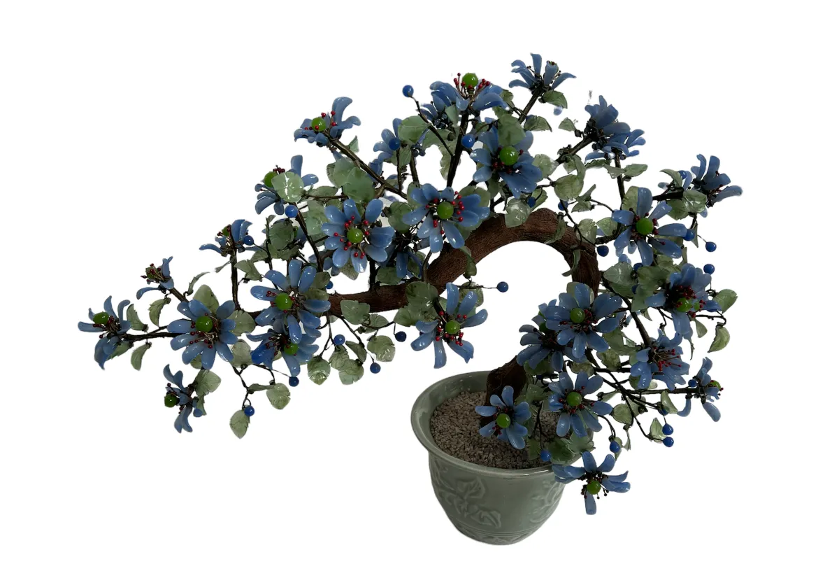 Bonsai antigo decorado com flores azuis em vaso.