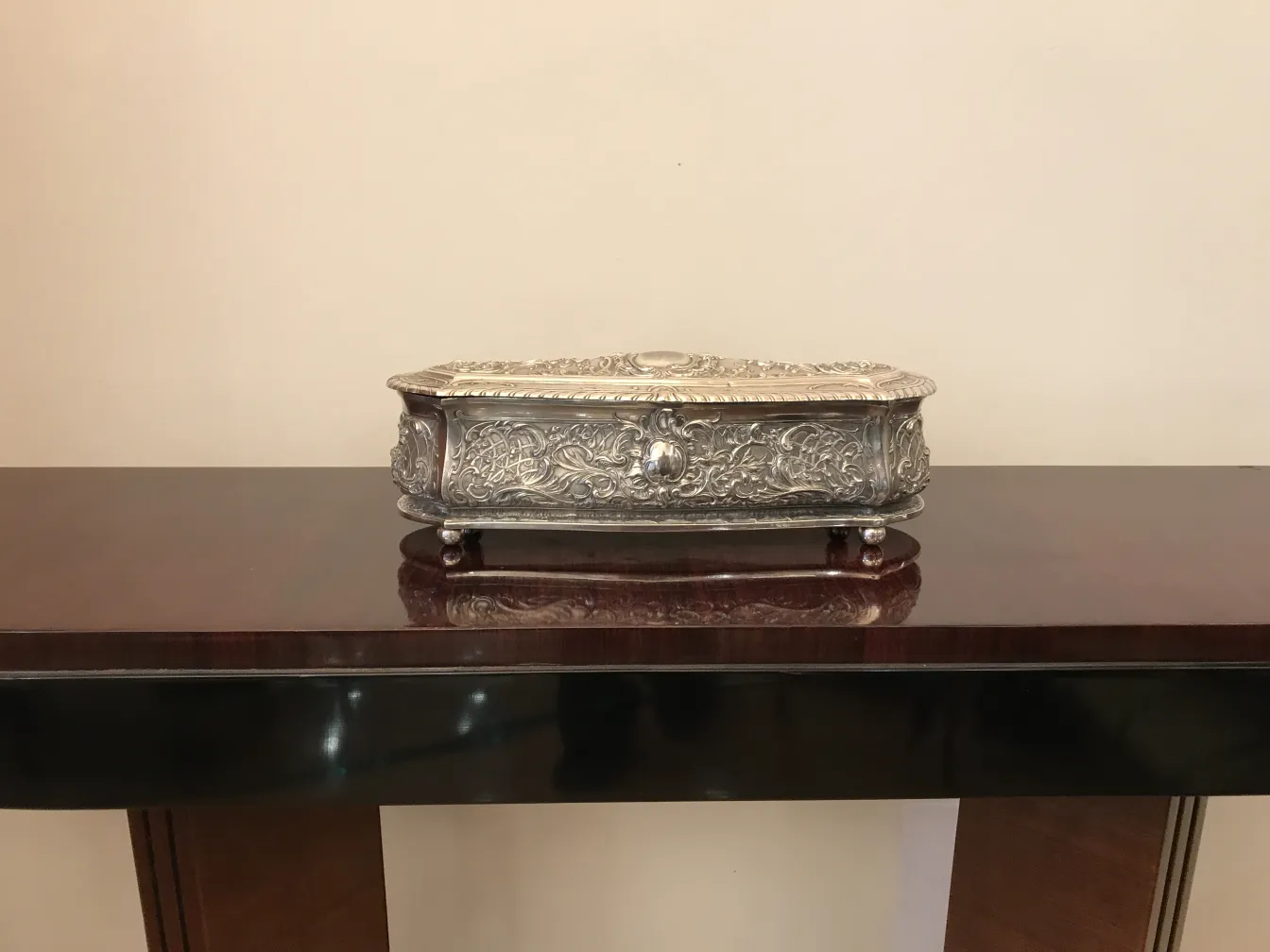 सजावटी प्राचीन डिब्बा, जो टेबल पर है।