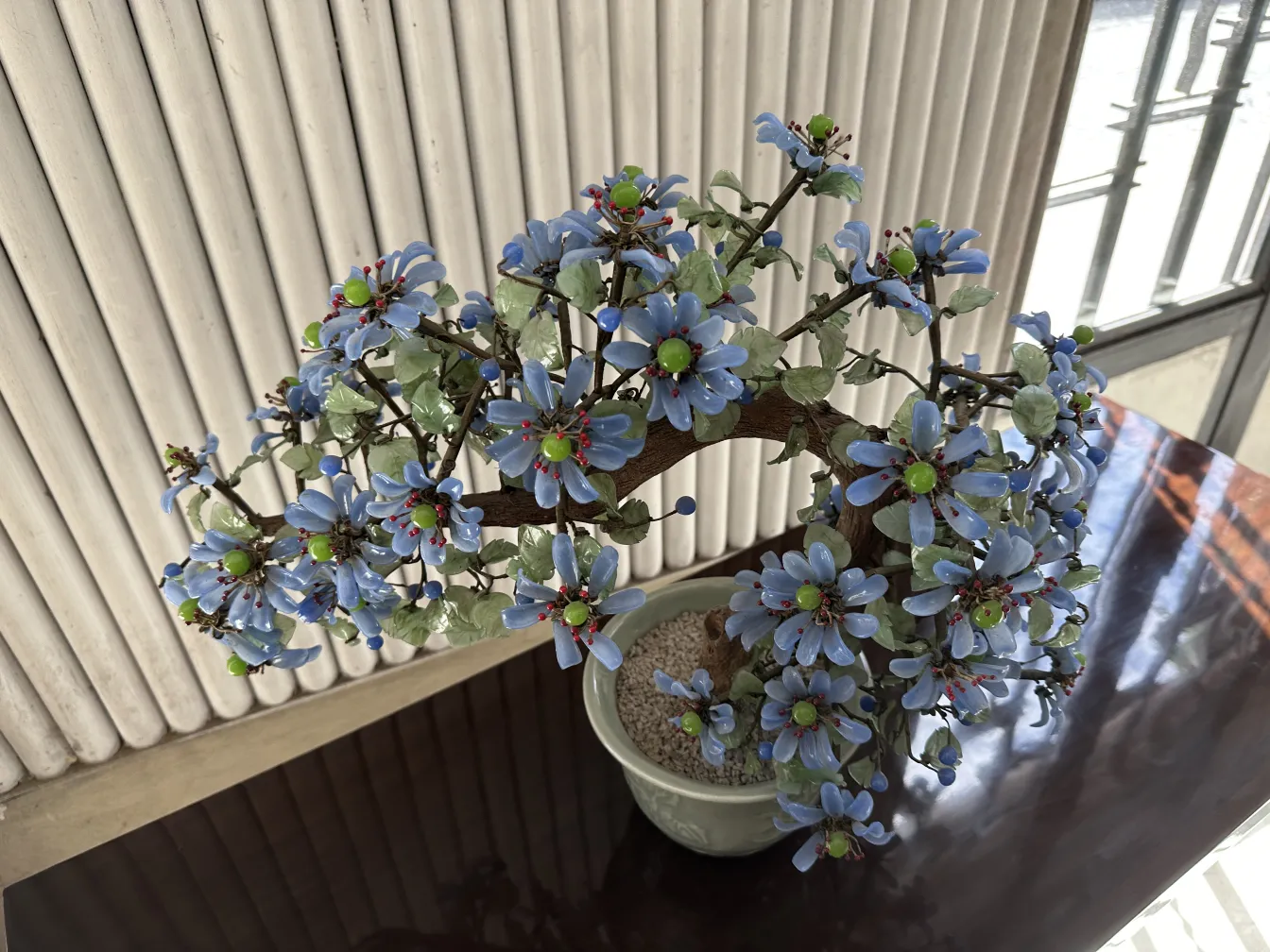 Antique bonsai with blue and green flowers, decorative.