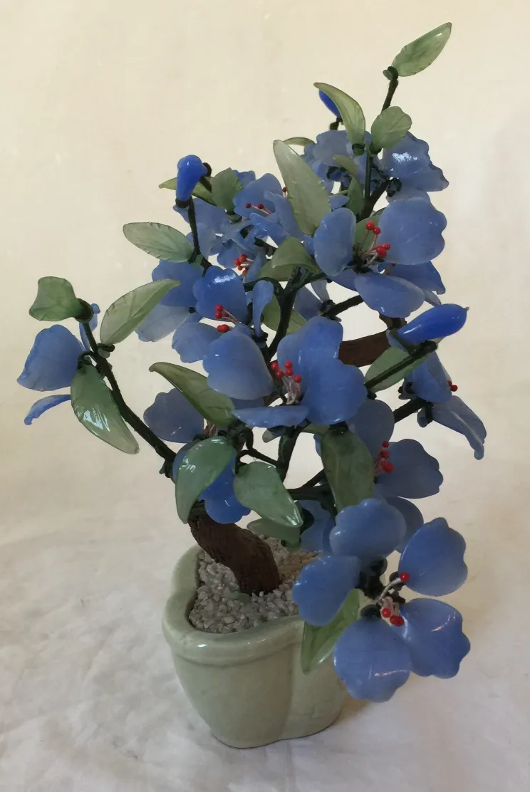 Beautiful antique bonsai with blue flowers and green details.