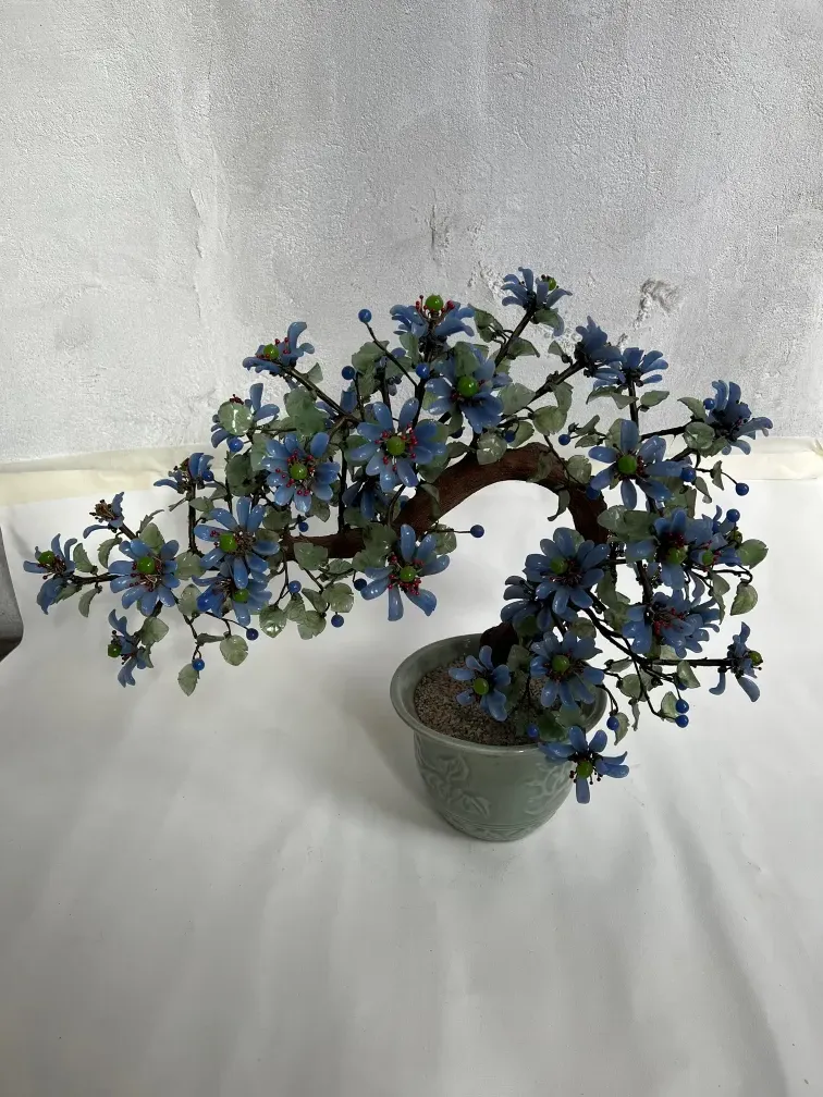 Bonsaï ancien avec des fleurs bleues et rouges dans un pot décoratif