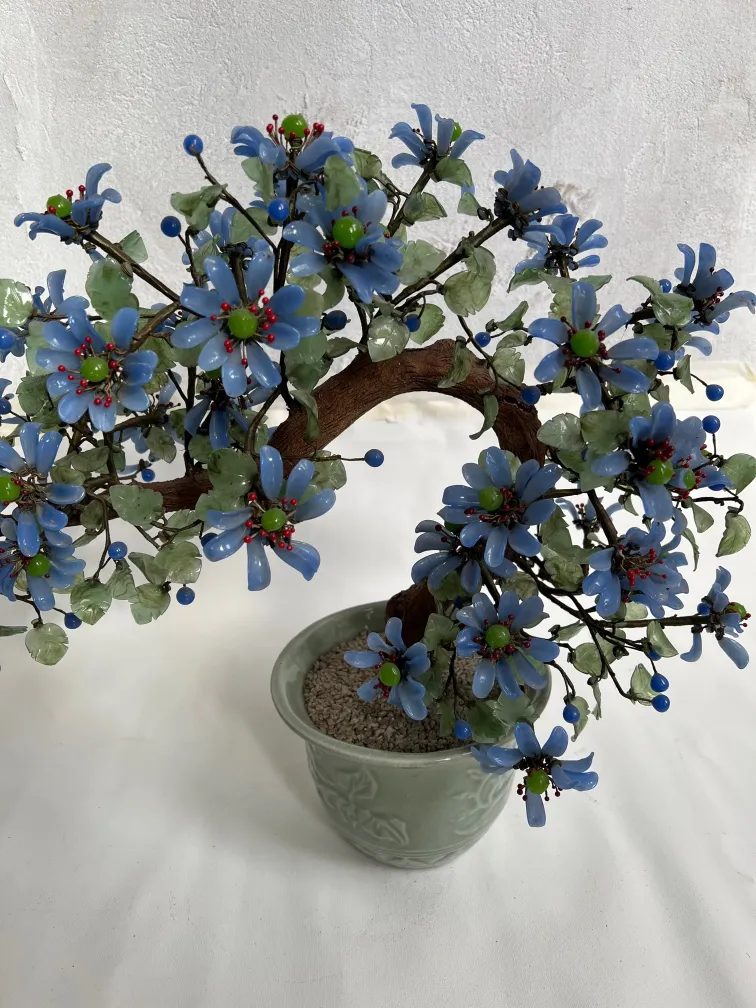 Bonsai antigo decorado com flores azuis e verdes
