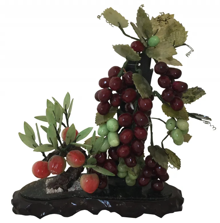 Bonsái antiguo con ramas de uvas y frutos rojos.