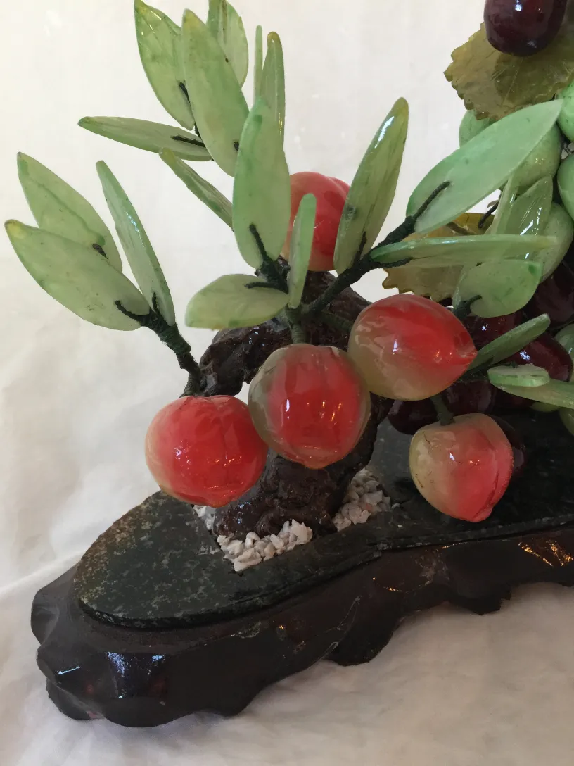 Antiker Bonsai mit grünen Blättern und dekorativen roten Früchten