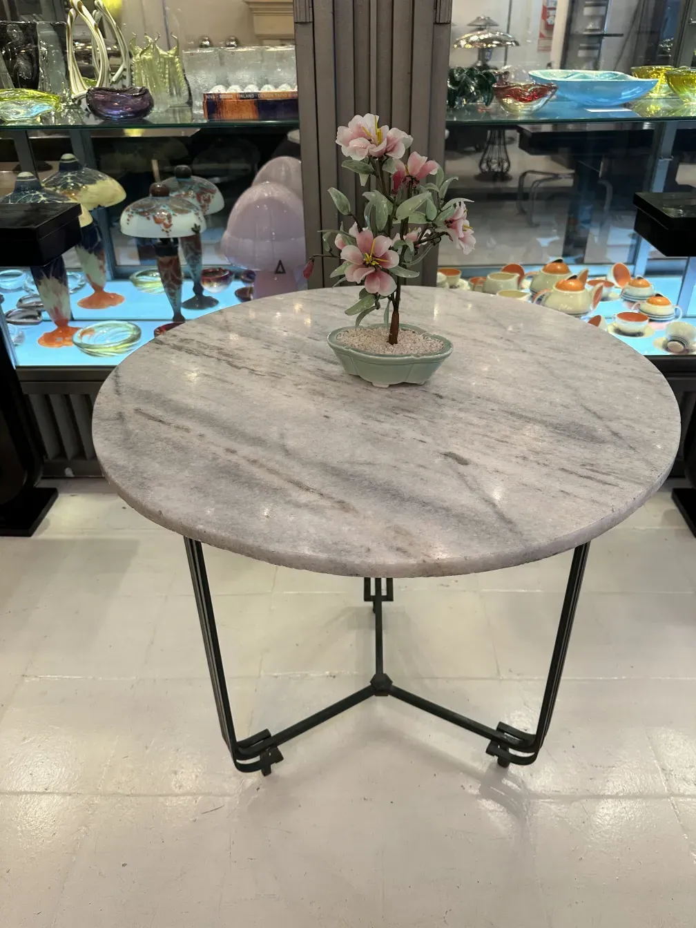 Antiker Bonsai in einem Topf mit zarten Blumen auf einem Marmortisch