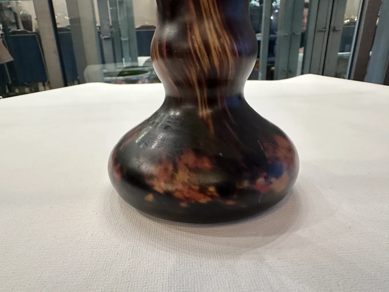 Vaso curvilineo in tonalità scure con dettagli sottili.