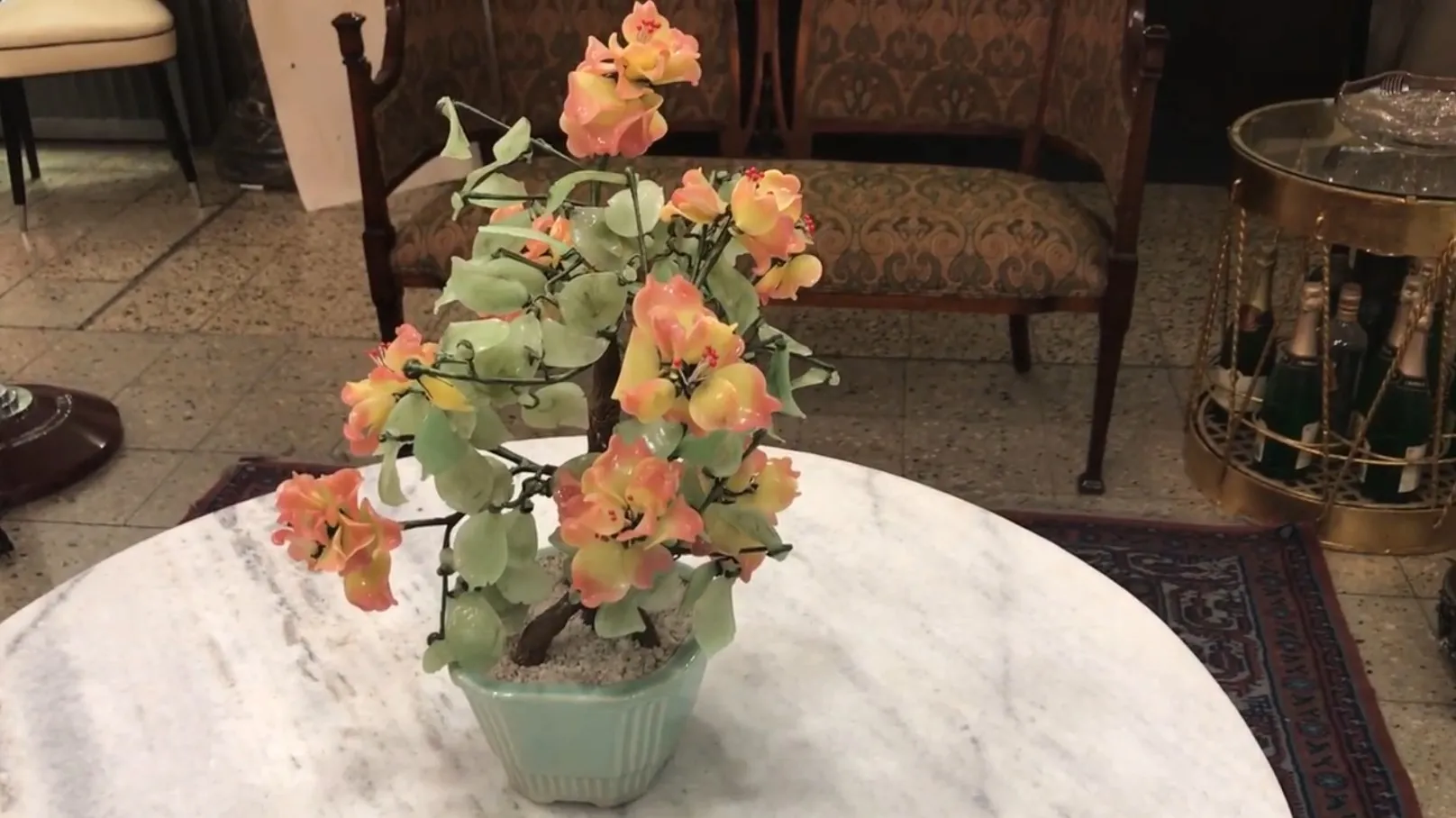 Bonsai antico con fiori colorati su un tavolo elegante.