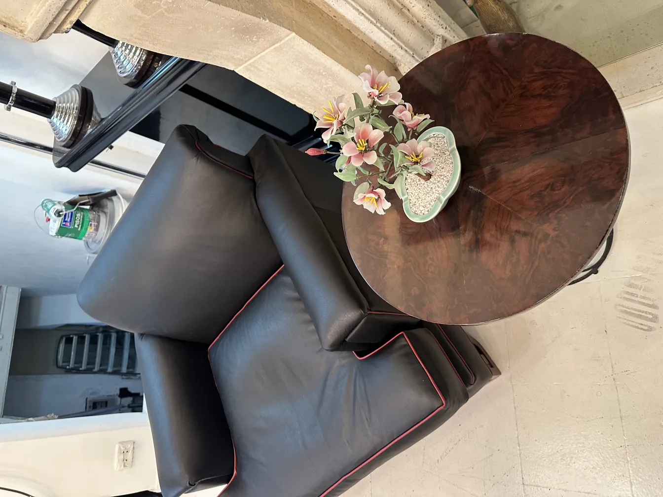 Bonsaï ancien dans un pot décoratif sur une table ronde avec des fleurs.
