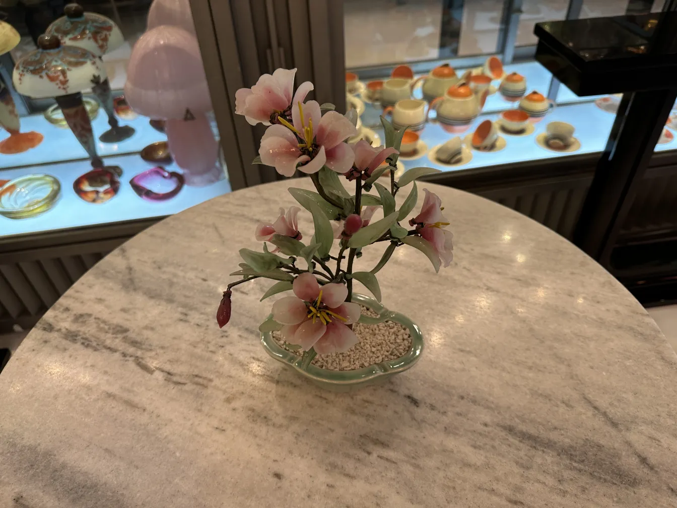 Bonsaï ancien avec des fleurs roses et des feuilles vertes, décoratif.