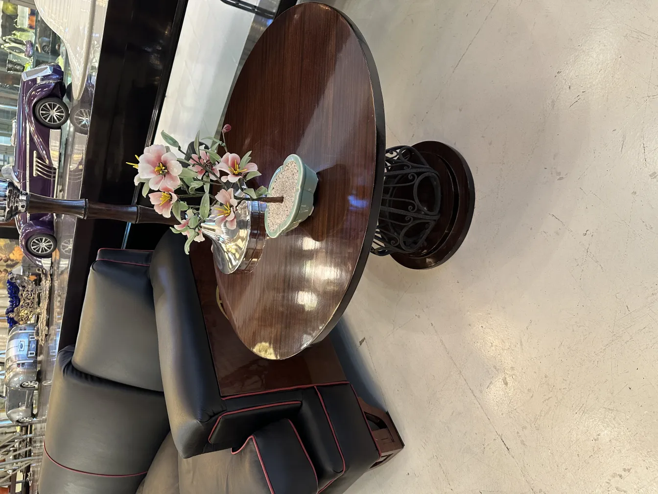 Bonsaï ancien dans un pot en céramique avec des fleurs décoratives et une ambiance élégante.