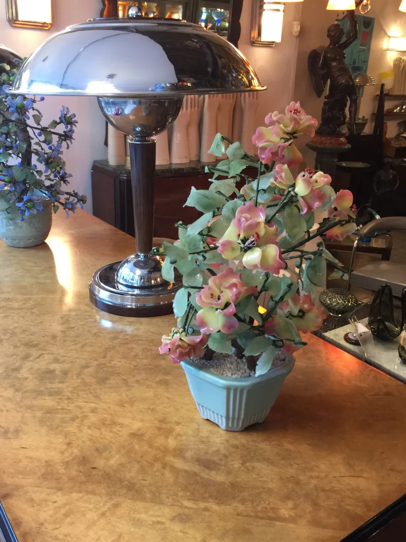 Antiker Bonsai in einem dekorativen Topf mit hellgrünen Blättern und Blumen