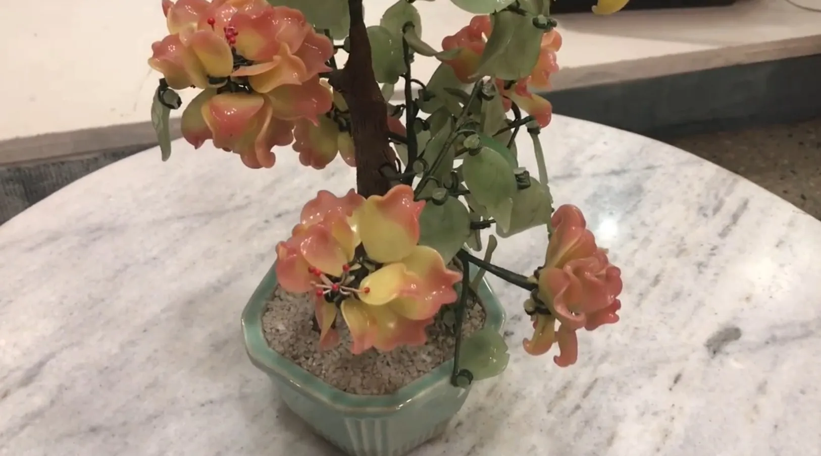 Bonsai antigo bonito com flores artificiais de cores suaves em um vaso.