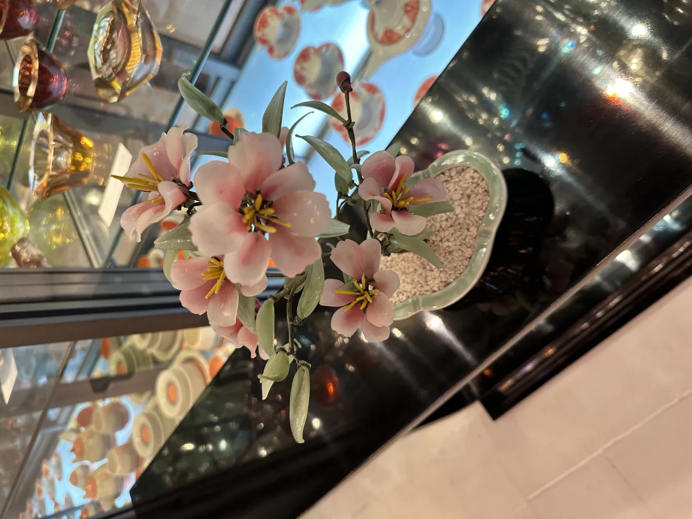 Bonsaï ancien avec des fleurs roses et vertes, décoratif.