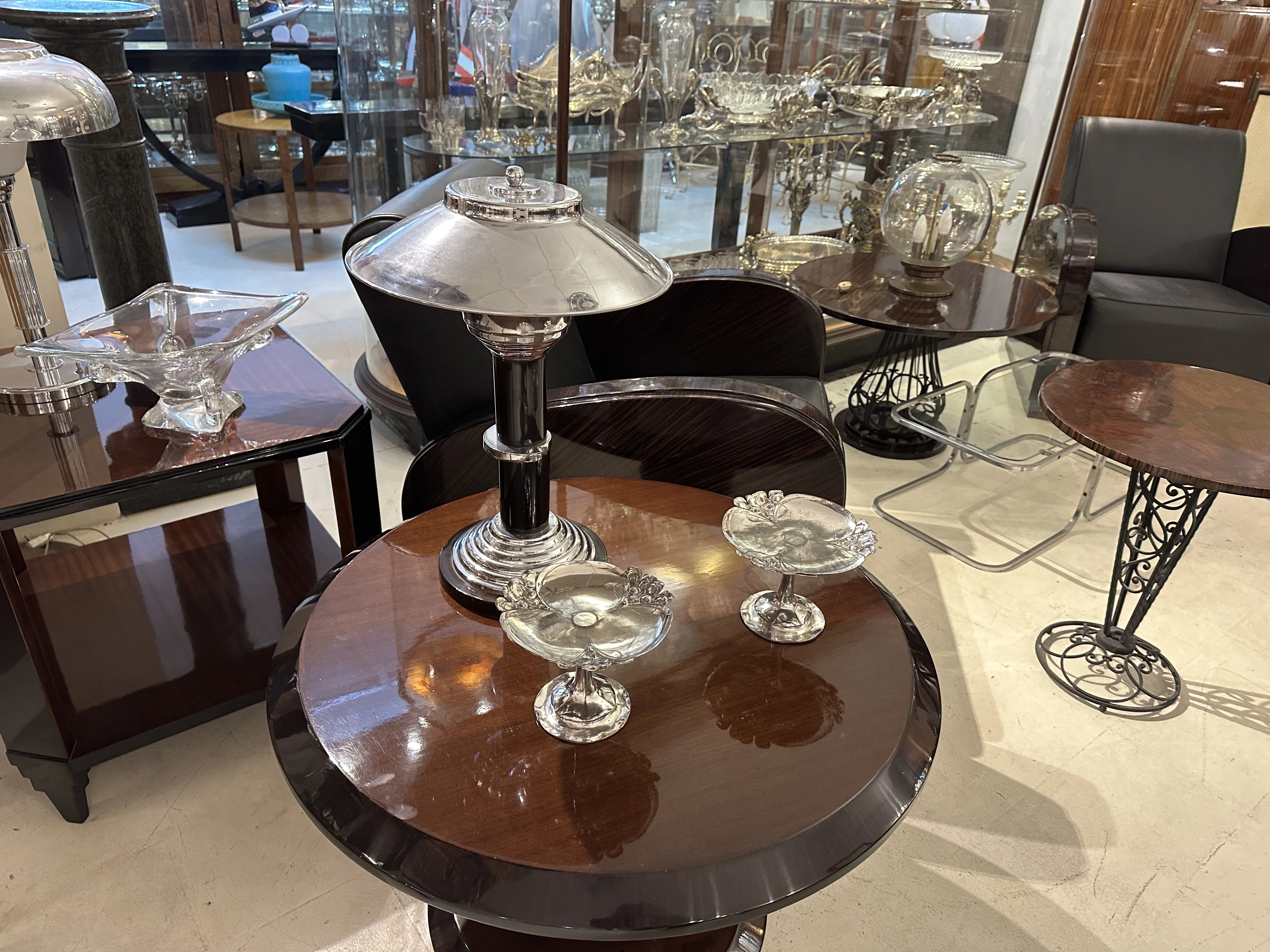 bandeja de cartas antiga WMF sobre uma mesa de madeira, cercada por outros objetos decorativos antigos.