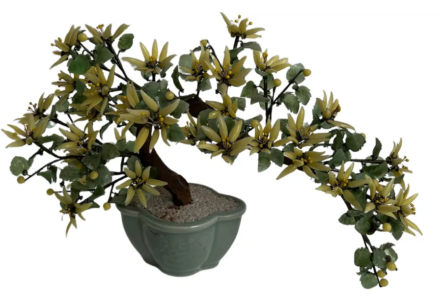 Antiker Bonsai mit gelben Blüten und grünen Blättern in einem Topf.
