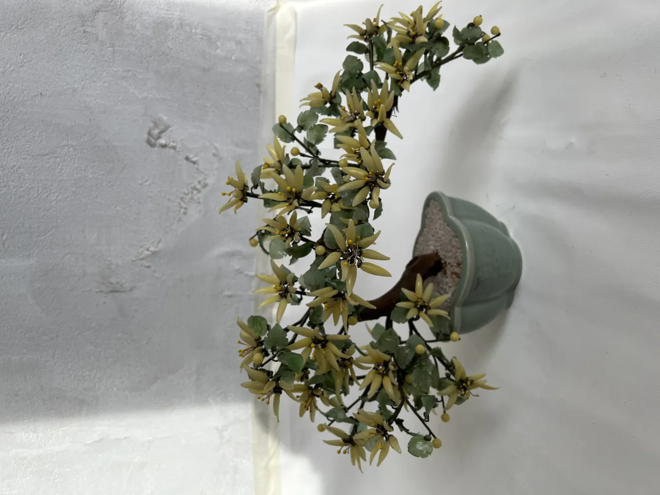 Bonsai antico decorativo con fiori gialli in vaso verde.