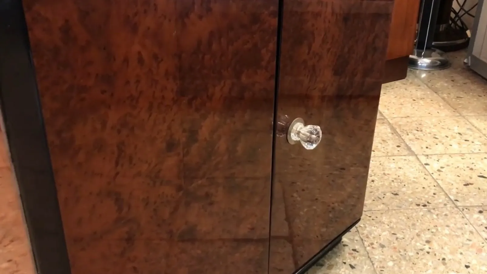 Antique bar cabinet with shiny surface and clear glass knob. Perfect for decor.