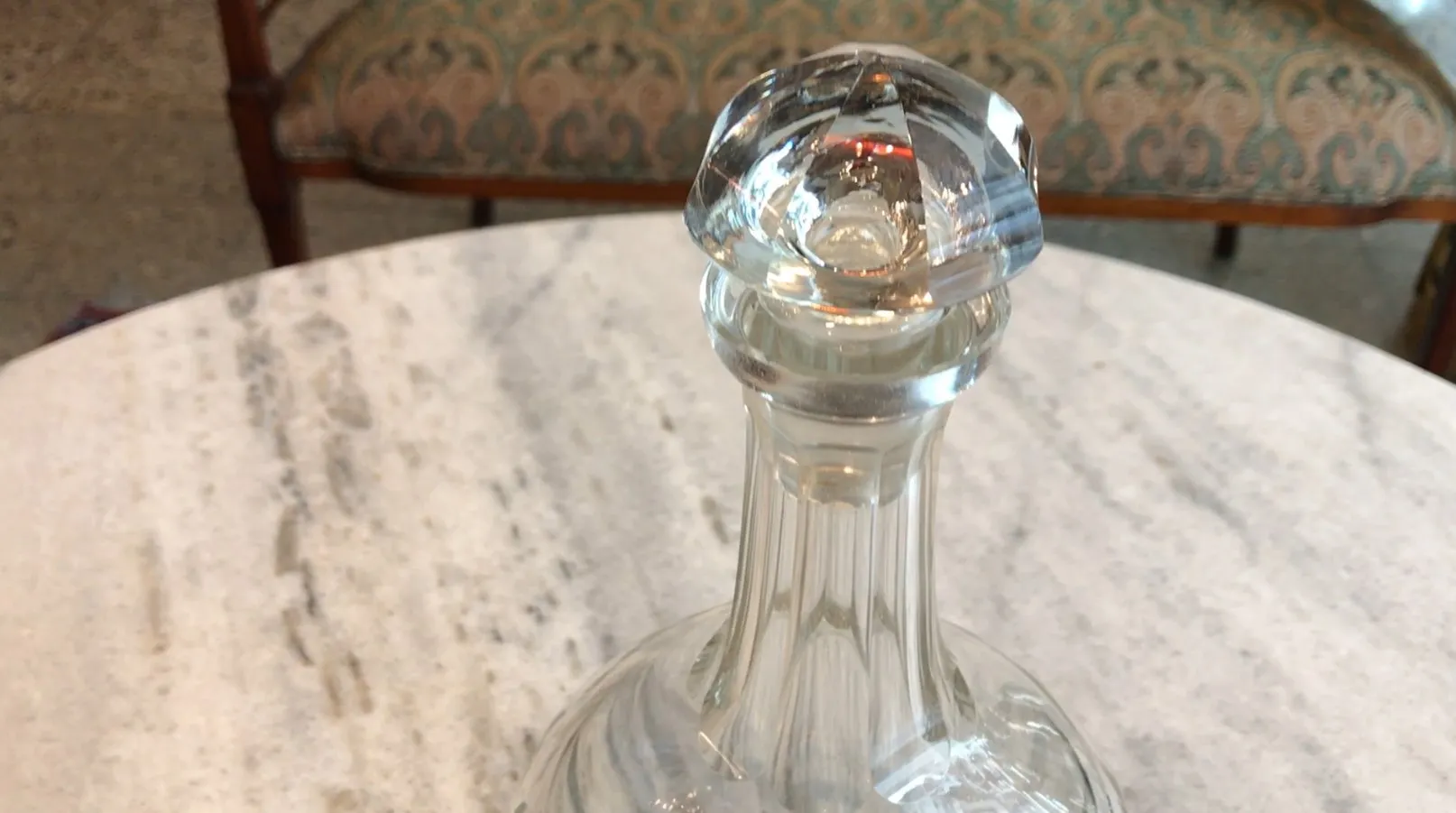 bouteille ancienne avec un design élégant et un bouchon décoratif sur une table en marbre
