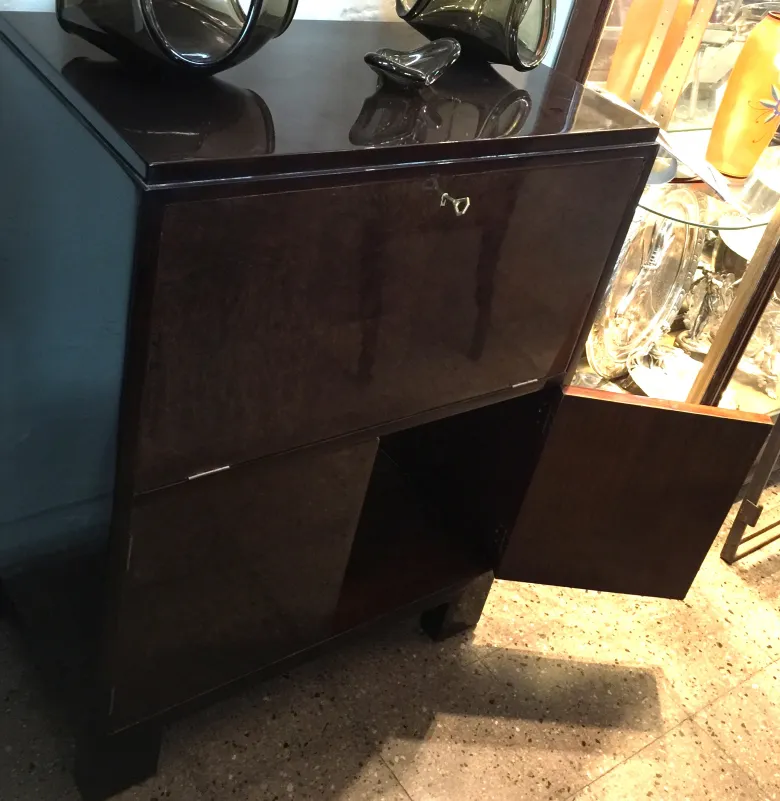 Antiker Cocktailschrank mit glänzender Oberfläche und dunklem Hintergrund.