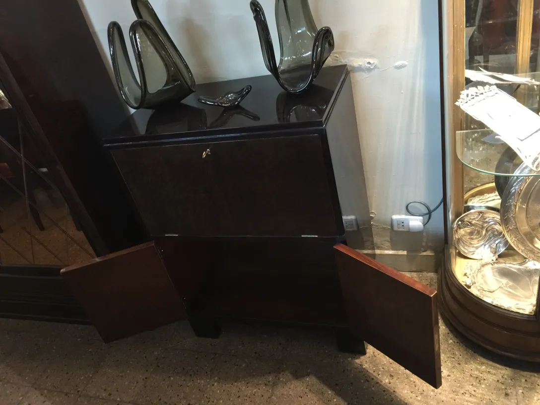 어두운 색의 앤틱 바 캐비닛, 열린 문과 화병으로 장식되어 있습니다.