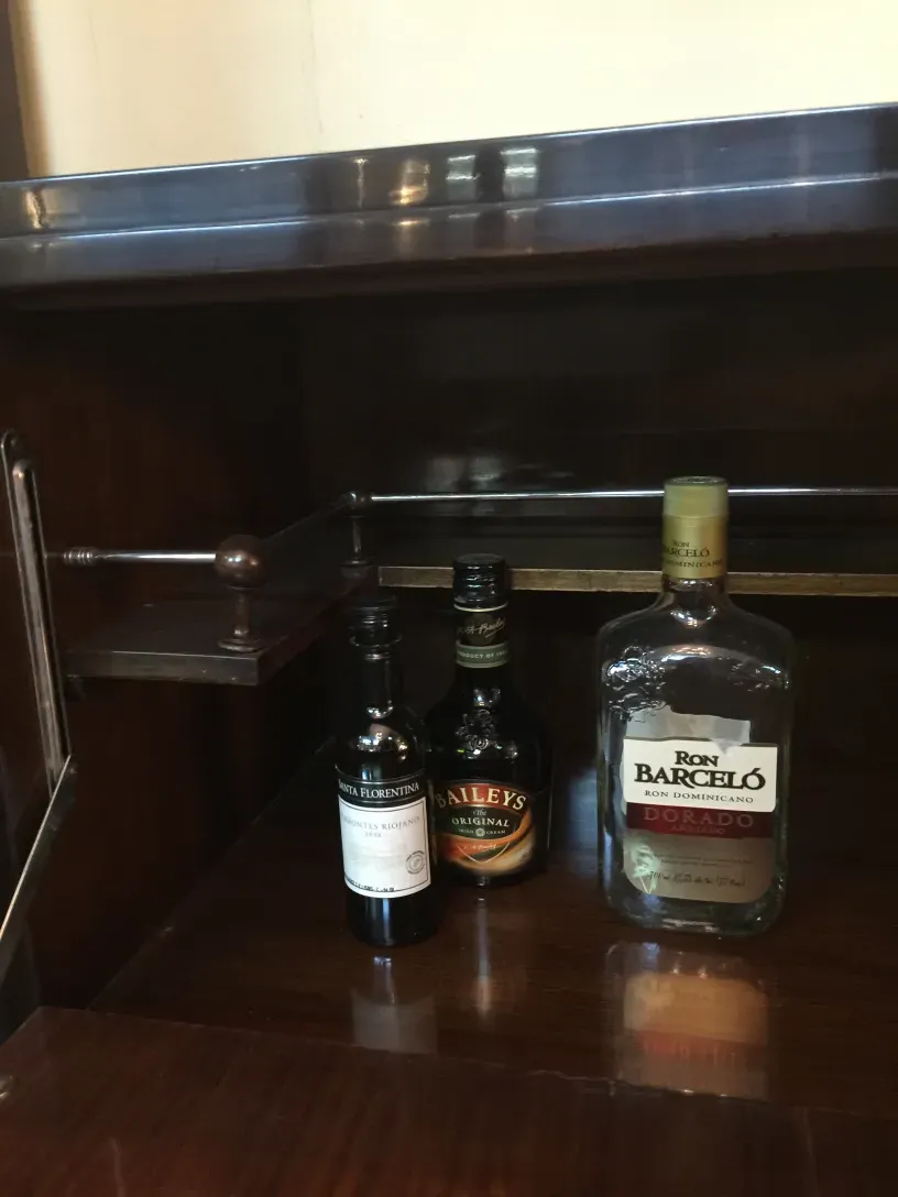 Mueble bar antiguo con botellas de licor en su interior
