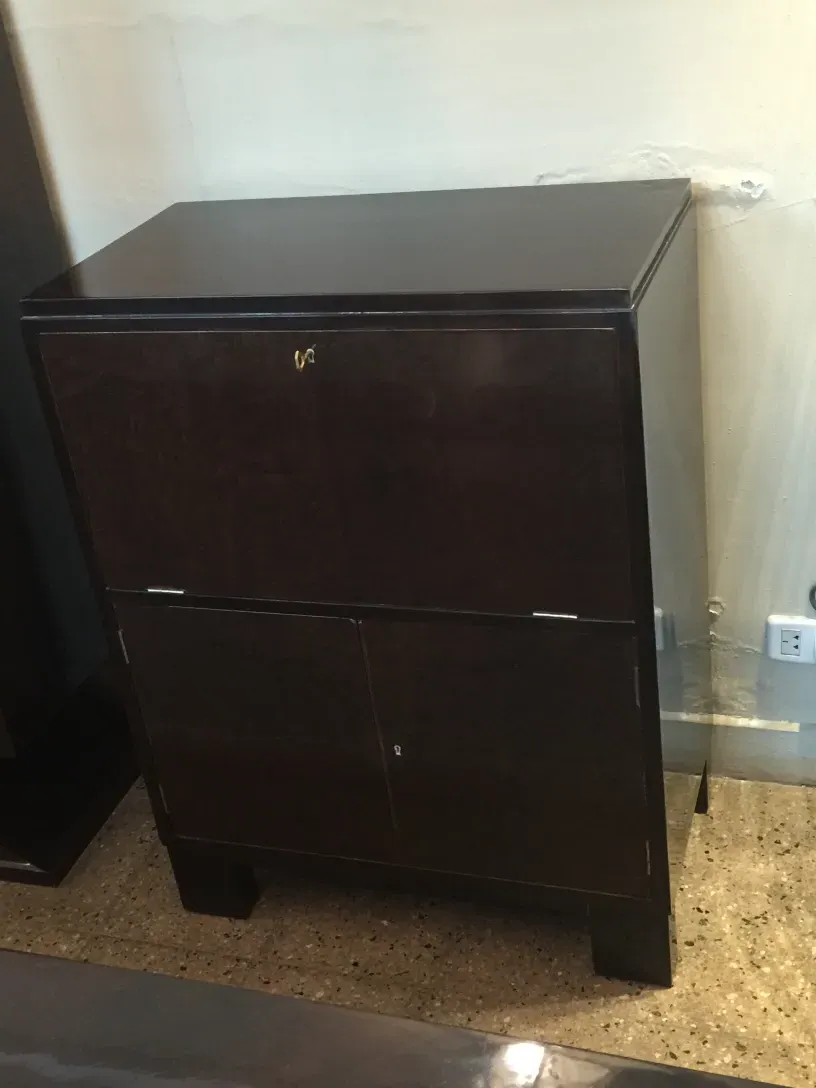 Mueble bar antiguo con acabado oscuro y detalles elegantes.