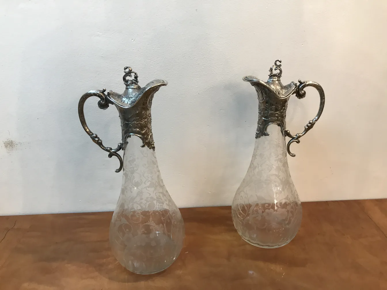 duas jarras antigas WMF com design intricado e alças decorativas, em um ambiente elegante